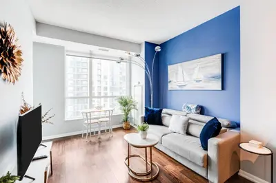a living room with blue walls and a couch at AOC Suites - High-Rise Condo - City View in Toronto