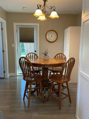 a dining room table with chairs and a clock on the wall at Villa in the Vines in Niagara on the Lake