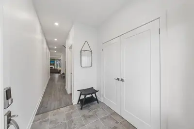 a hallway with white cabinets and a black stool at Jewel of Blue Mountain - Walk to Ski and Village - EV plug in Blue Mountains