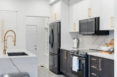 a kitchen with black and white appliances and a sink at Jewel of Blue Mountain - Walk to Ski and Village - EV plug in Blue Mountains