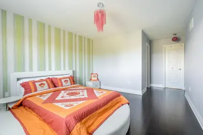 a bedroom with a large bed with an orange blanket at Beautiful Family Villa, Pond Facing with Huge Backyard in Brampton