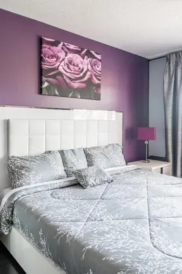 a bedroom with a white bed with a purple wall at Beautiful Family Villa, Pond Facing with Huge Backyard in Brampton