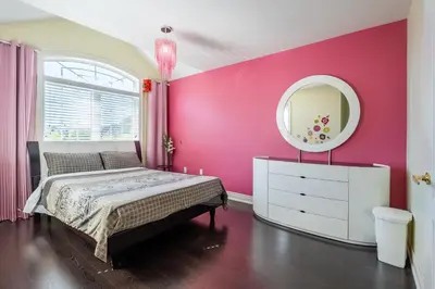 a pink bedroom with a bed and a mirror at Beautiful Family Villa, Pond Facing with Huge Backyard in Brampton