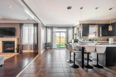 a kitchen with a table and chairs and a fireplace at Beautiful Family Villa, Pond Facing with Huge Backyard in Brampton