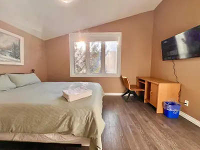 a bedroom with a bed and a desk and a television at Newly Renovated Home in Central Aurora in Aurora