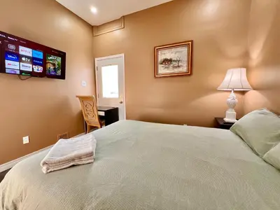 a bedroom with a large bed and a flat screen tv at Newly Renovated Home in Central Aurora in Aurora