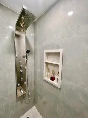 a bathroom with a shower with a sink and a mirror at Newly Renovated Home in Central Aurora in Aurora