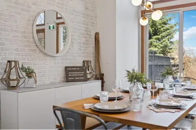 a dining room with a table and a mirror at The Parker House Gorgeous Light and Spacious Chalet 86100 in Blue Mountains