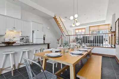 a dining room with a table and a kitchen at The Parker House Gorgeous Light and Spacious Chalet 86100 in Blue Mountains