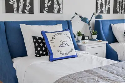 a blue and white bed with a pillow on it at The Parker House Gorgeous Light and Spacious Chalet 86100 in Blue Mountains