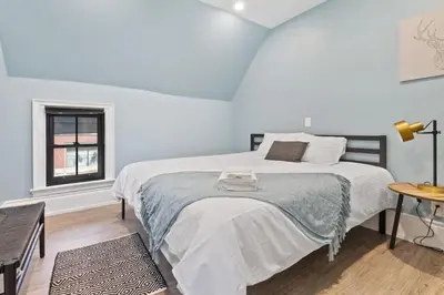 a bedroom with a large white bed and a window at Bright and Spacious Condo in Downtown Collingwood 97043 in Collingwood