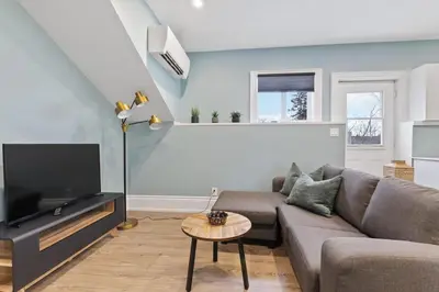 a living room with a couch and a flat screen tv at Bright and Spacious Condo in Downtown Collingwood 97043 in Collingwood