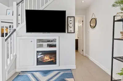 a living room with a fireplace and a flat screen tv at Blue Mountain The Parker Slopeside in Blue Mountains