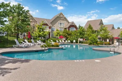 a swimming pool with chairs and a house at Spectacular Rivergrass Chalet Steps to Blue Mtn in Blue Mountains
