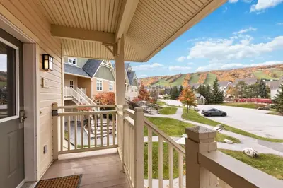 a house with a balcony with a view of a street at Spectacular Rivergrass Chalet Steps to Blue Mtn in Blue Mountains