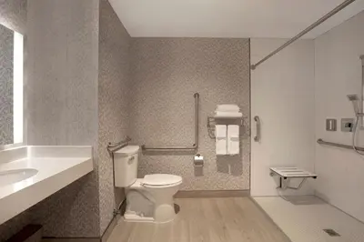 a bathroom with a toilet and a sink at Great Blue Heron Hotel in Port Perry