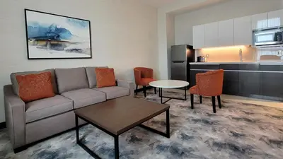 a living room with a couch and a table and a kitchen at Pickering Casino Resort in Pickering