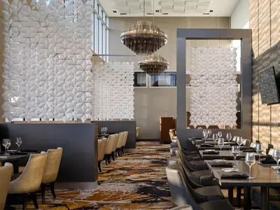 a dining room with tables and chairs and a wall at Pickering Casino Resort in Pickering