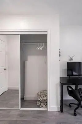 a white room with a desk and a table and a chair at Harmony Home Near University of Waterloo in Waterloo