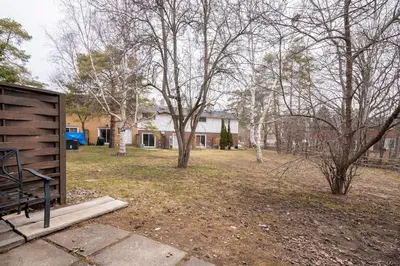 a yard with trees in front of a house at Harmony Home Near University of Waterloo in Waterloo