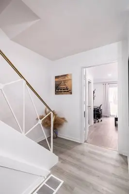 a white hallway with a staircase in a house at Harmony Home Near University of Waterloo in Waterloo