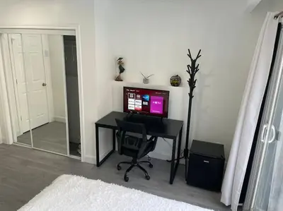 a room with a desk with a computer and a television at Harmony Home Near University of Waterloo in Waterloo