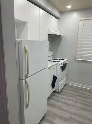 a white kitchen with a stove and a refrigerator at Harmony Home Near University of Waterloo in Waterloo
