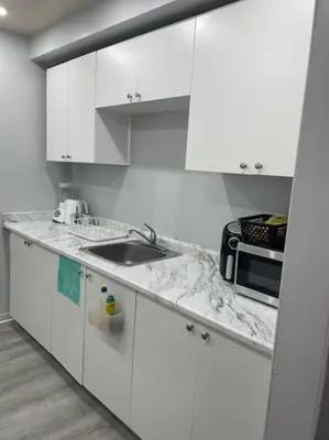a white kitchen with a sink and a microwave at Harmony Home Near University of Waterloo in Waterloo