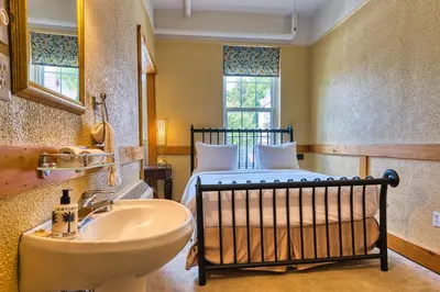 a bathroom with a bed and a sink in a room at The Stratford Hotel by Hoco Hotels Collection in Stratford