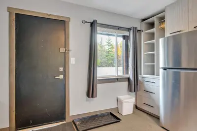 a kitchen with a refrigerator and a window at Moira Lake Motel in Madoc