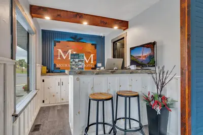 a kitchen with two stools at a bar at Moira Lake Motel in Madoc