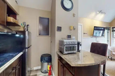 a kitchen with a stove and a clock on the wall at Condo 912 at North Creek Resort in Blue Mountains