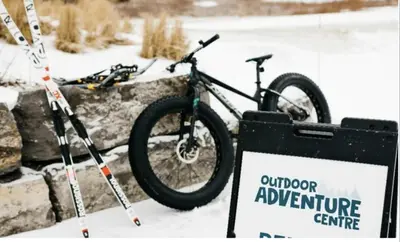 a bike parked next to a sign in the snow at Stunning Stayz Luxury 2 King Suite at Friday Harbour Resort Marina Walk & Parking in Innisfil