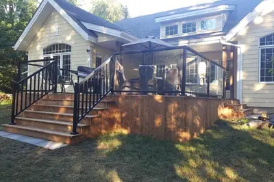 a house with a deck with some chairs on it at WELCOME TO BURNT RIVER ESTATE in Kawartha Lakes