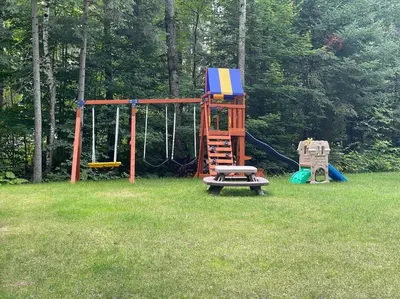 a playground with a bench and a swing at WELCOME TO BURNT RIVER ESTATE in Kawartha Lakes