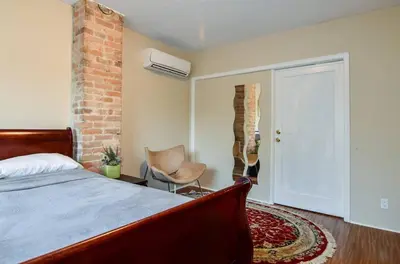 a bedroom with a bed and a brick wall at Downtown Retreat-Spacious Rooms with Shared Kitchen & Bath in Toronto