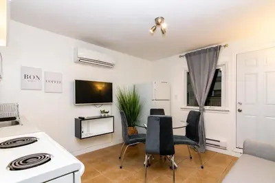 a kitchen with a stove and a table with chairs at Downtown Retreat-Spacious Rooms with Shared Kitchen & Bath in Toronto