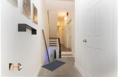 a hallway with white walls and a blue stairway at Downtown Retreat-Spacious Rooms with Shared Kitchen & Bath in Toronto