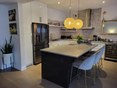 a kitchen with a black island with bar stools at Exclusive Townhome near West-Side Trails in Waterloo