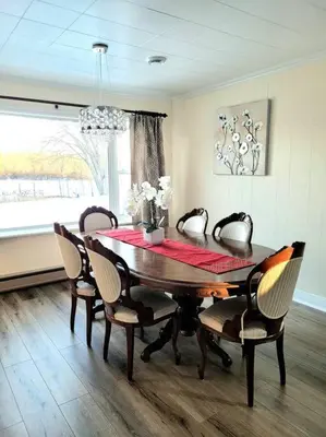 a dining room with a wooden table and chairs at Pines Bay Waterfront cottage with Hot tub! in Kawartha Lakes