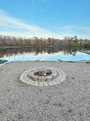 a fire pit in the middle of a lake at Pines Bay Waterfront cottage with Hot tub! in Kawartha Lakes