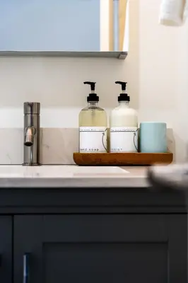 two bottles of soap and a cup on a counter at 