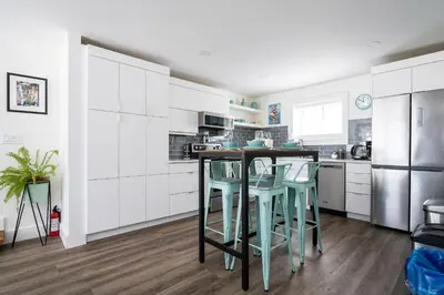 a kitchen with white cabinets and a table and stools at 