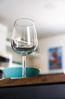 a glass of wine sitting on a table at 