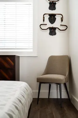 a bedroom with a chair next to a window at 
