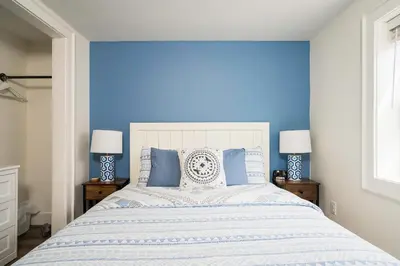 a blue bedroom with a large bed with blue walls at 