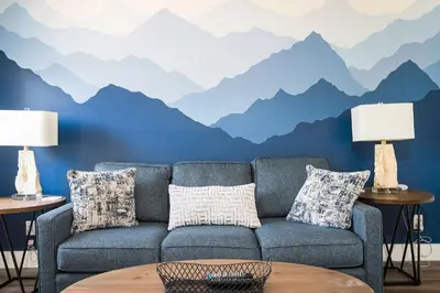 a living room with a couch and mountains mural at 