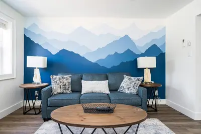 a living room with a blue couch and mountains mural at 