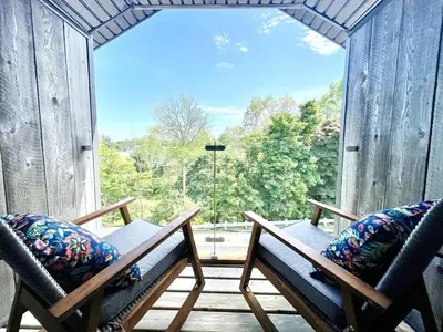 a screened in porch with two chairs and a large window at 