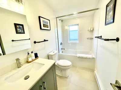 a white bathroom with a toilet and a shower at 